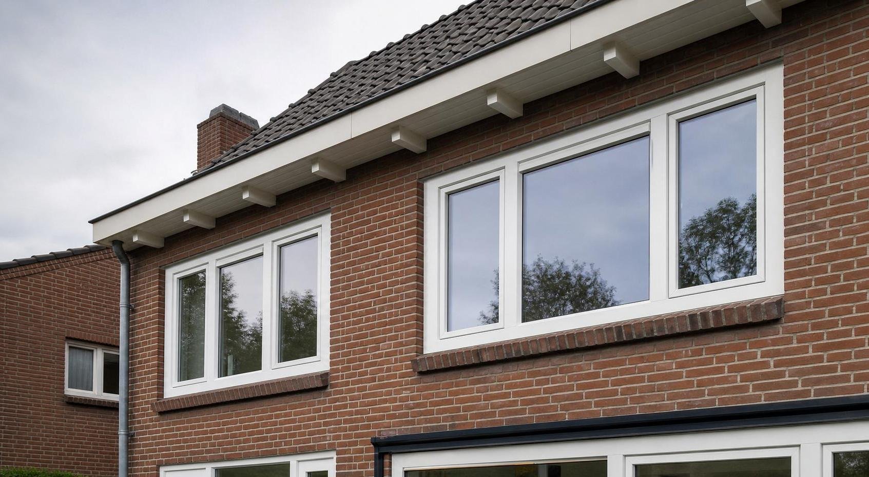 Upgraded brick house facade with white kunststof upper-floor windows and clean exterior detailing